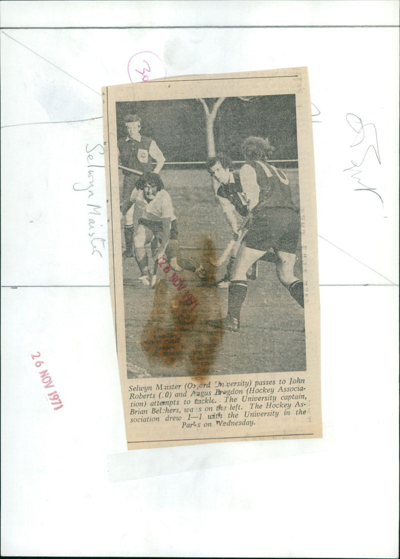 Selwyn Maister of the University passes to John Roberts, while Angus Bogdon of the Hockey Association attempts to tackle. - Vintage Photograph