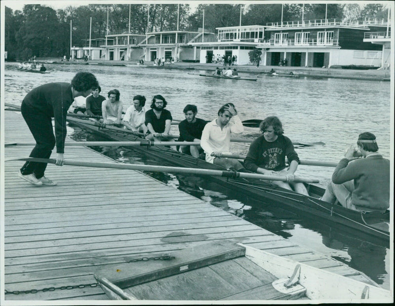 Robin Lowe gives a trial eight a shove to help it on its way during a practice row on the Isis in Oxford. - Vintage Photograph