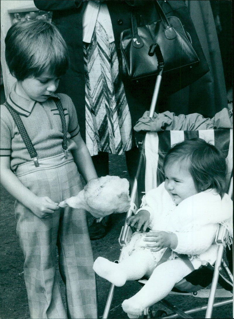 A four year old offers his candy floss to his one year old sister at St. Giles Fair. - Vintage Photograph