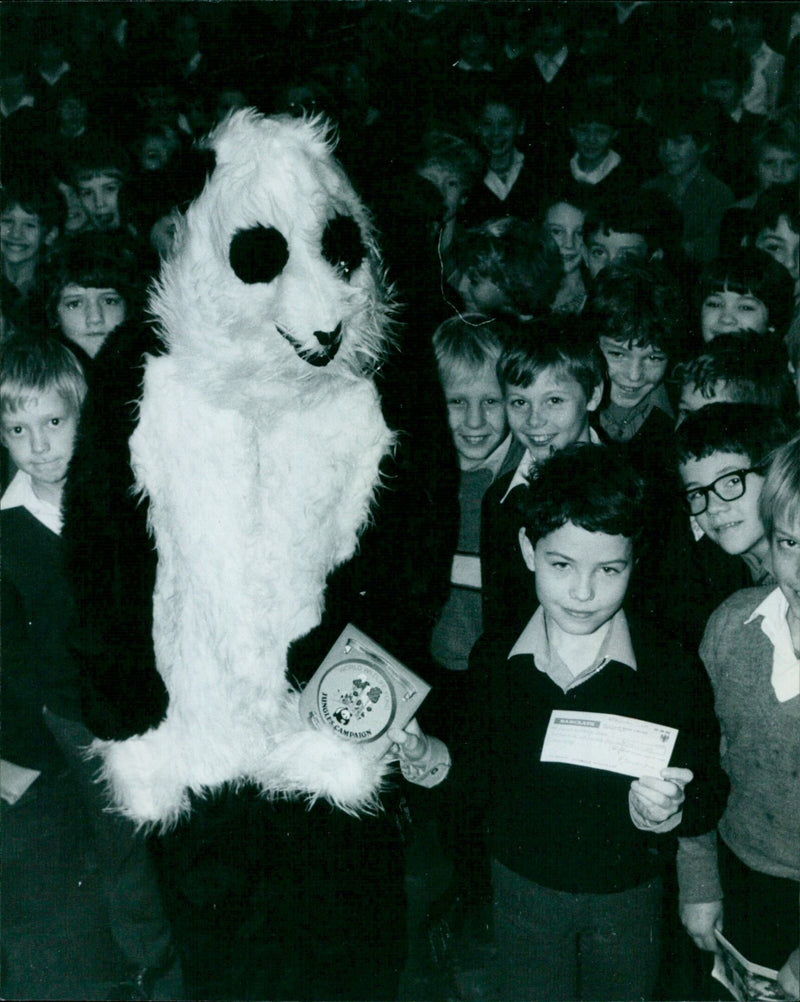 A panda stands atop a large tree stump in a forest near Barclays Bank in London. - Vintage Photograph