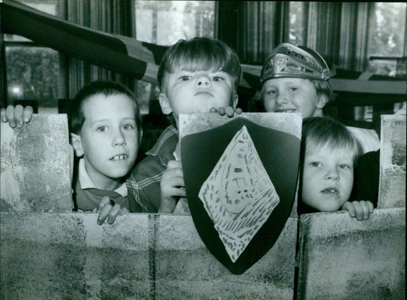 Seven children look out over the battlements of their paper castle at Barton Primary School. - Vintage Photograph