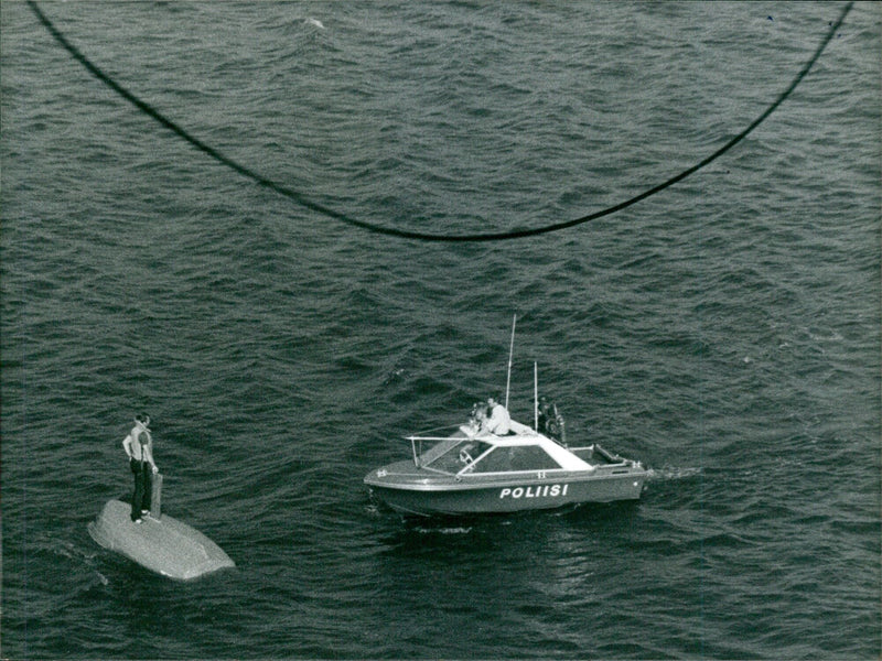 A police patrol boat rescues a man whose sailboat had overturned off the Helsinki coast. - Vintage Photograph