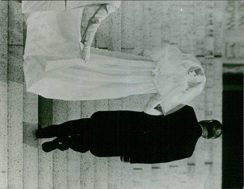 A couple embraces amidst a celebration of their wedding in Stockholm, Sweden on August 15, 1966. - Vintage Photograph