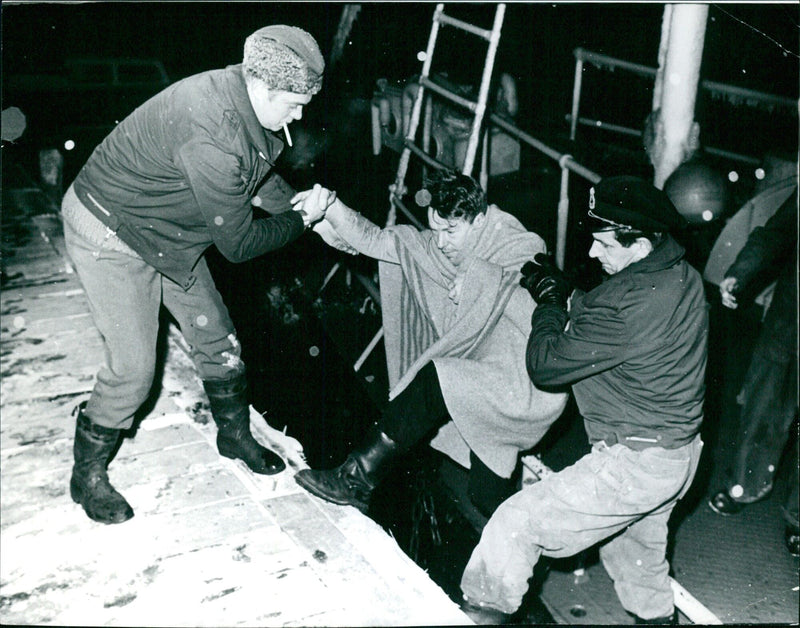 A vessel is assisted to land in Sandhamn, Sweden, on December 10, 1969. Stockholm's CODE 777 REPORTAGEBILD agency captured the moment. - Vintage Photograph