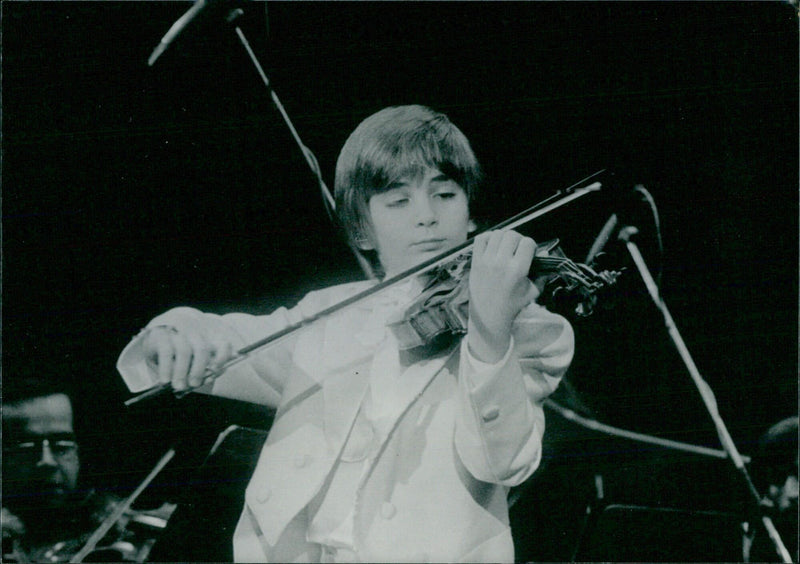 Nine-year-old violin prodigy Stefan Milenkovic performs during a European and American tour in late 1986/early 1987. - Vintage Photograph