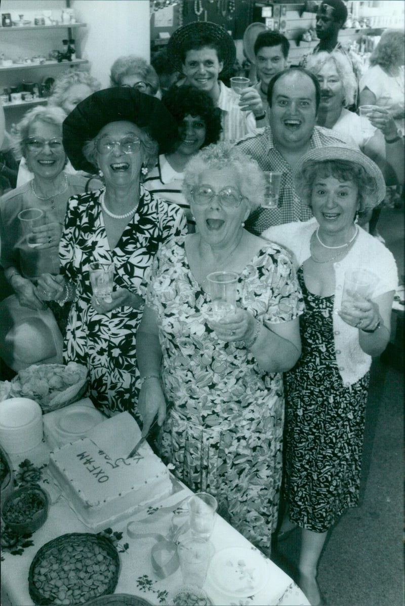 Mrs. Margaret Bell, a volunteer for Oxfam, cuts the cake during the 50th Birthday celebration of the charity in Oxford. - Vintage Photograph