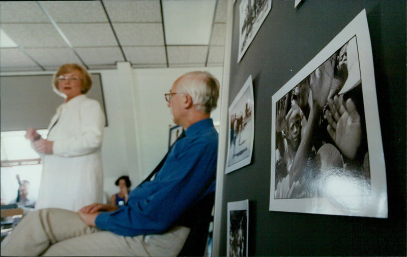 Oxfam staff receives a talk from Oxfam Director Glenys Kinnick. - Vintage Photograph