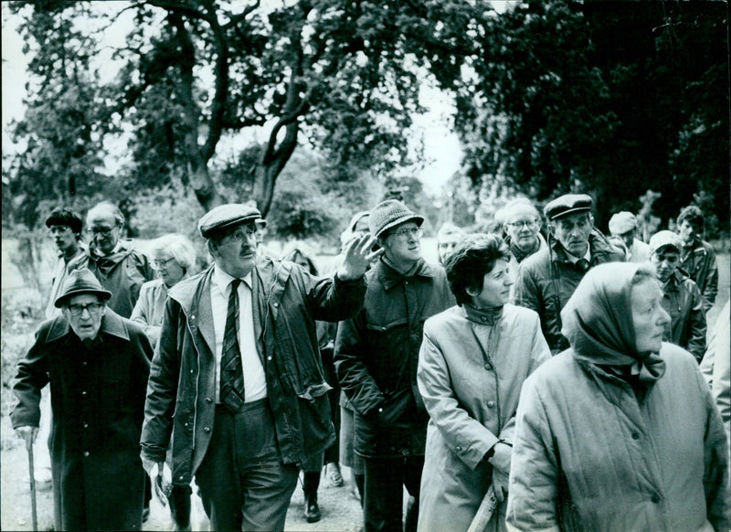 A group of students and their professor take a guided walk through a university park. - Vintage Photograph