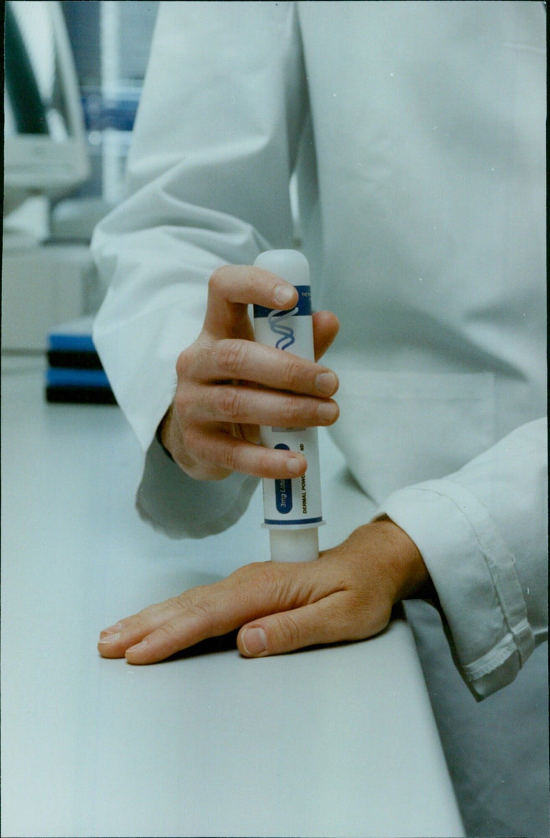 A technician holds a container of 3mg Lido Dermal Powder, a product of Oxford Ecgt, during production. - Vintage Photograph