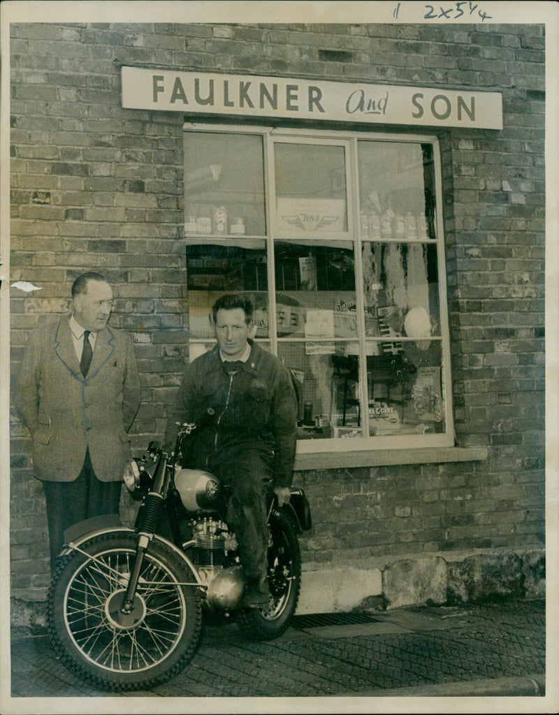 Mr. R.G. Faulkner and his son, Bill Faulkner, pose outside the building that housed their family business. - Vintage Photograph