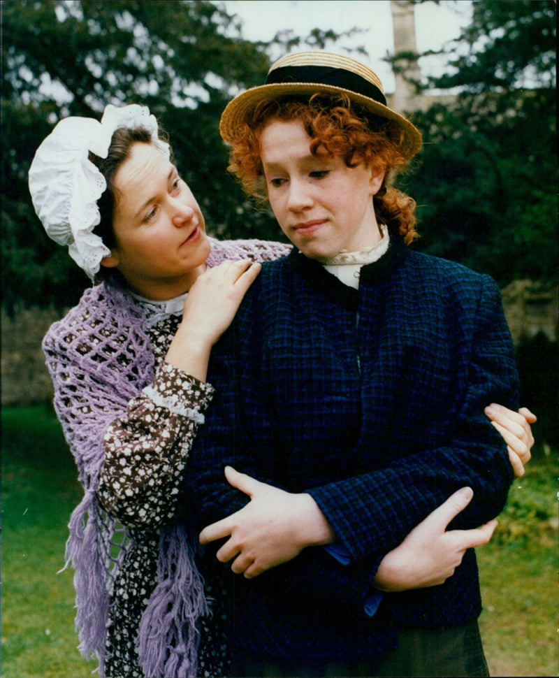 Emma Timms (Katy Bushell, left) and her daughter, Laura (Carys McConville), share a moment at the Candleford Theatre on March 3, 1992. - Vintage Photograph