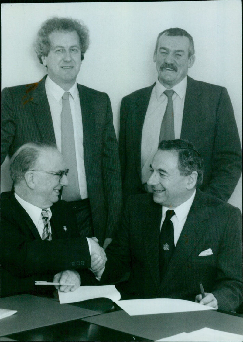 Senior partners from two local firms join forces at a handshake ceremony. - Vintage Photograph