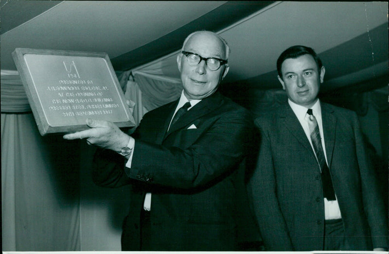 Mr. J.R. Edwards, Director of B.M.H., holds a plaque presented to him at the official opening of the new R.&. Building at Pressed Steel. - Vintage Photograph