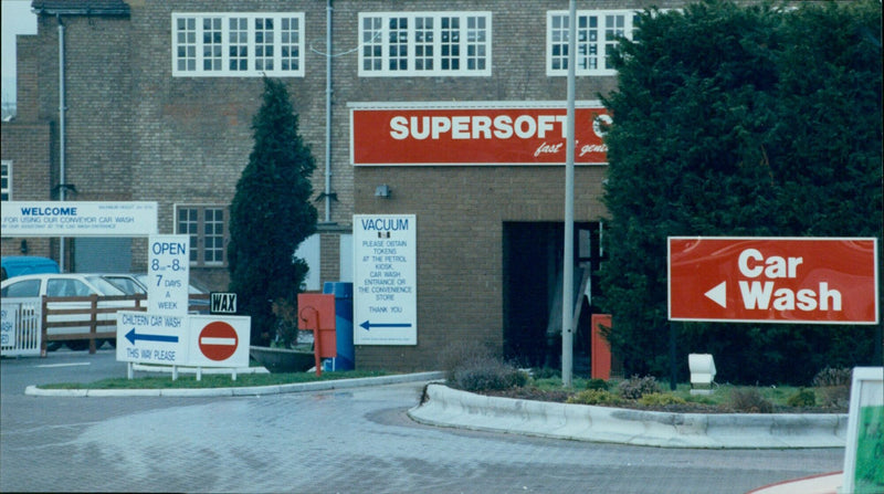 A car wash attendant stands in front of a sign advertising the services of the Chiltern Car Wash, Woodstock. - Vintage Photograph