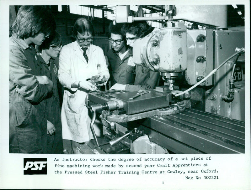 An instructor evaluates the accuracy of a machined piece of work made by Craft Apprentices at the Pressed Steel Fisher Training Centre in Cowley, UK. - Vintage Photograph