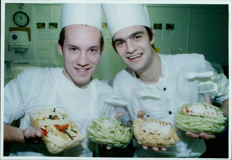 Richard Bodimeade and Alex Cooper watch Pedro Vieira prepare food at Cowley Howard and Howard Caterers. - Vintage Photograph