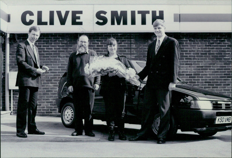 Mrs. Boyes is presented with a bouquet by Barrie Chalk of Clive Smith Oxford Limited. - Vintage Photograph