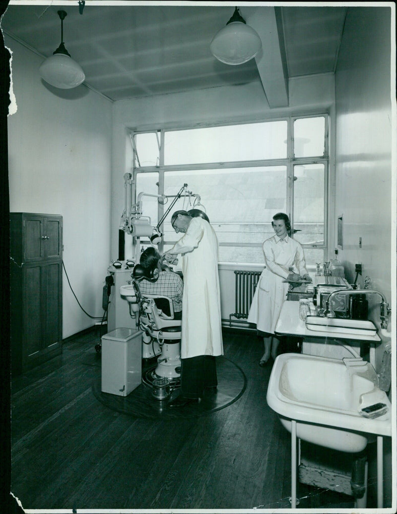 A worker at a factory in England using a telephone. - Vintage Photograph