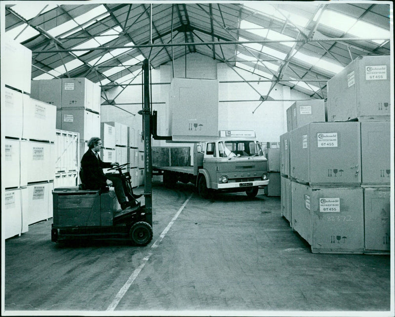 Employees unload a large shipment of deep freezers in Oxford, England. - Vintage Photograph