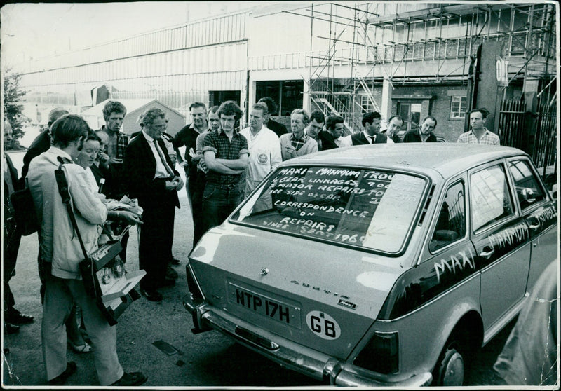 Mrs. Evelyn McGuigan stands with her car outside of a Cowley factory on Friday. - Vintage Photograph