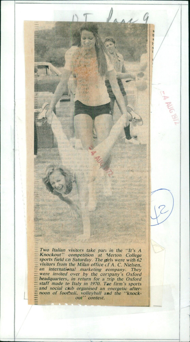 Two Italian visitors participate in a "It's A Knockout" competition at Merton College sports field. - Vintage Photograph