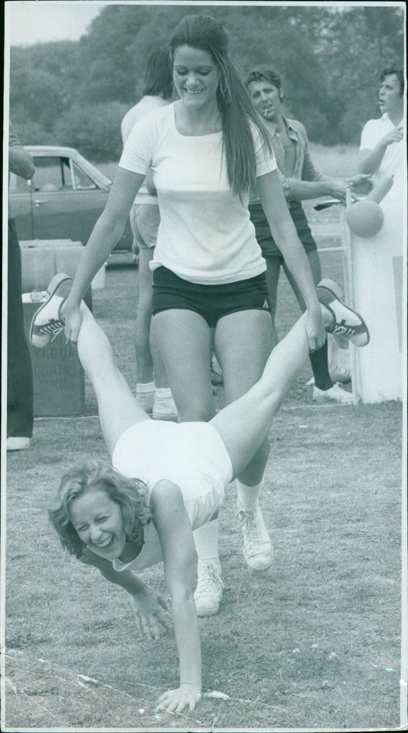 Two Italian visitors participate in a "It's A Knockout" competition at Merton College sports field. - Vintage Photograph