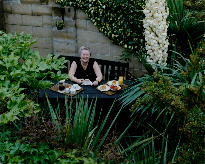 Pearl Bevan stands with her container garden in Litzemore. - Vintage Photograph