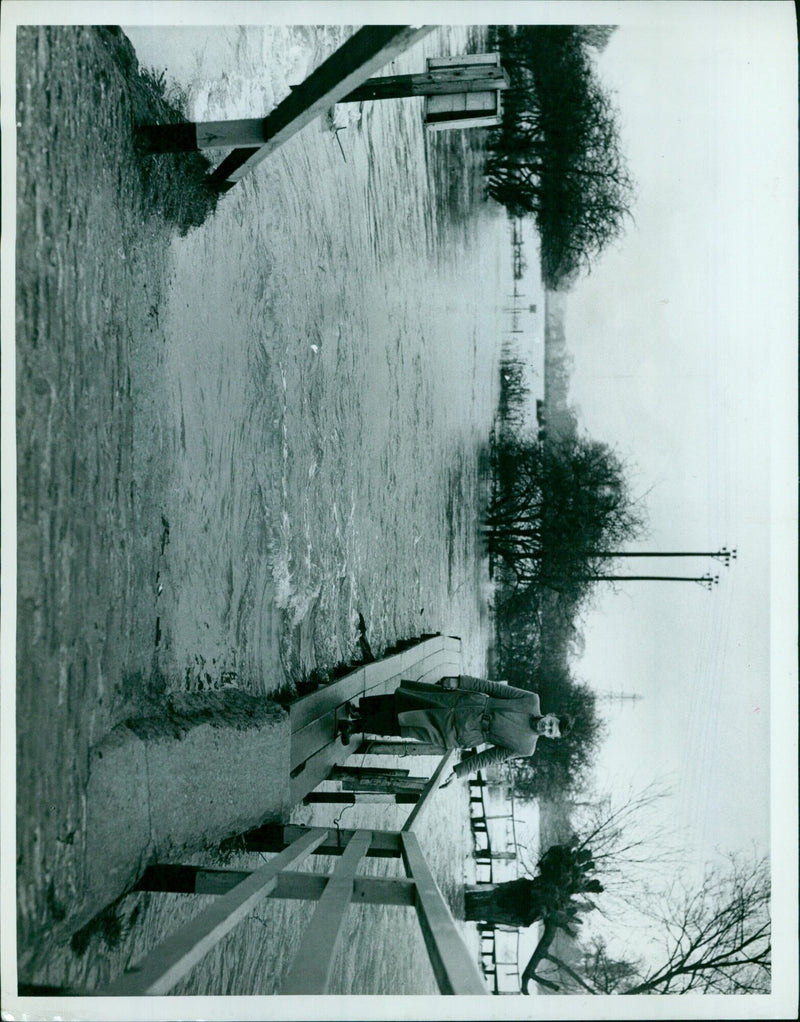 Pedestrians walking along a raised footpath in Karachi, Pakistan. - Vintage Photograph