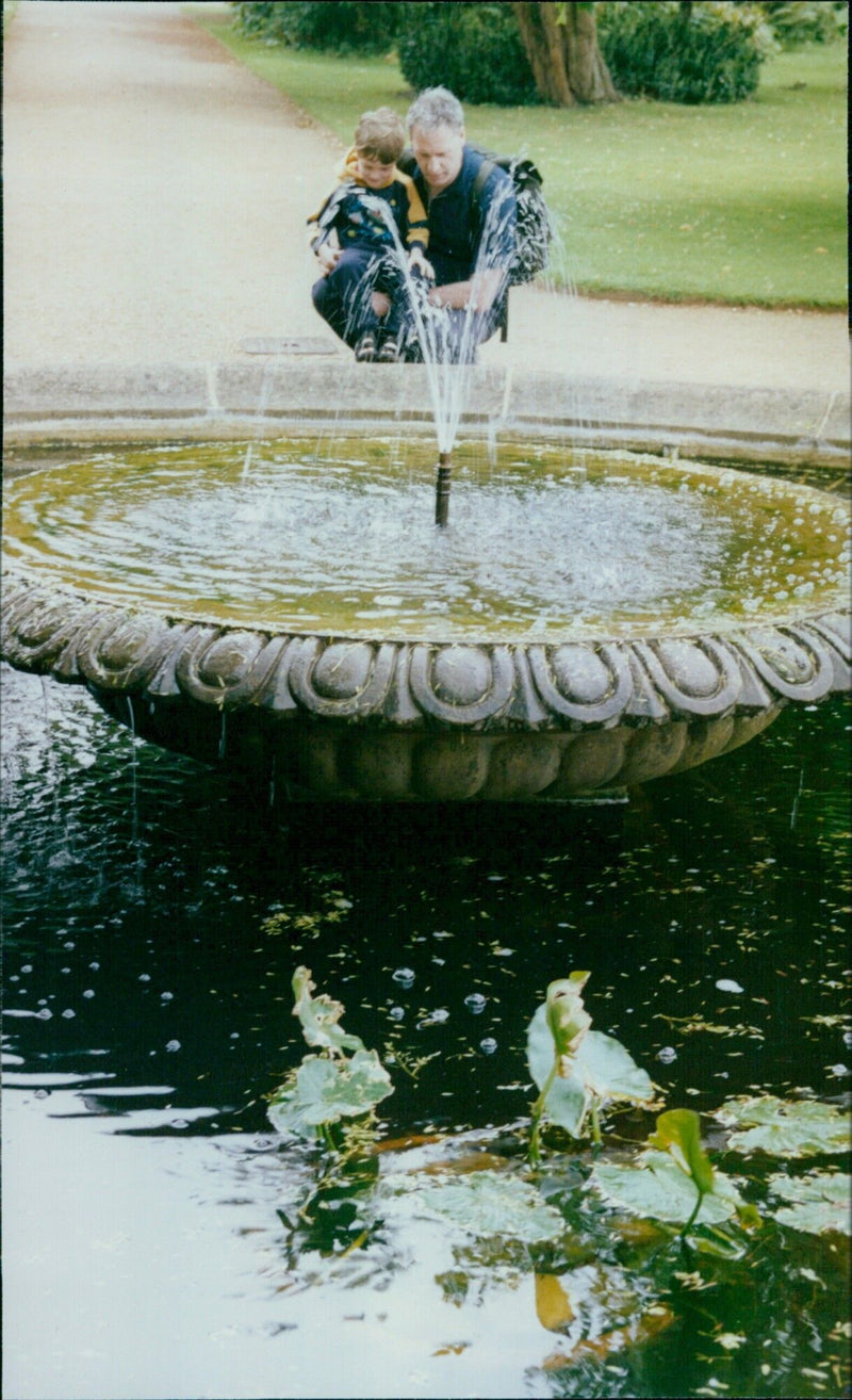 Gardeners Andrea Dowling and Patsy Dyer work on the new bog area at Oxford Botanic Garden, while Anne Russell, her daughter Sheila Jessett, Alan Philp and his son Andrew take a break from their holiday from Australia by the fountain. - Vintage Photograph