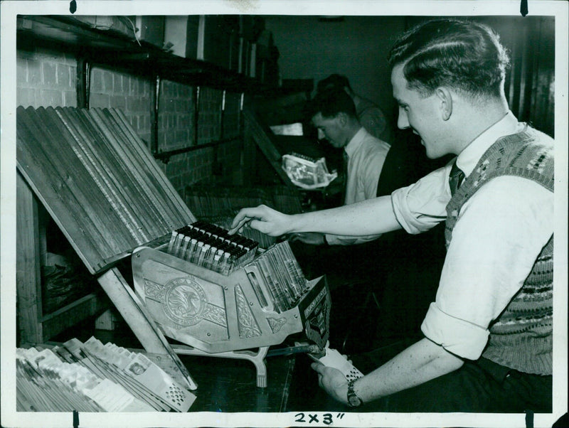 Workers at a factory in Warsaw, Poland operating an automated production machine. - Vintage Photograph