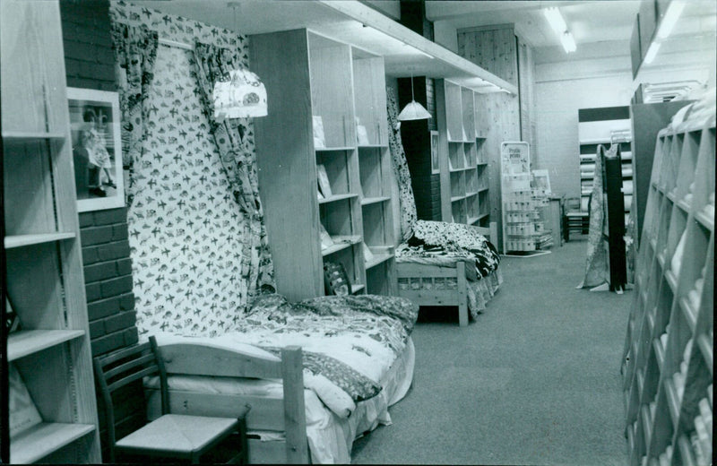 A woman browses through fabric swatches at the Johnsons 280 store in London. - Vintage Photograph