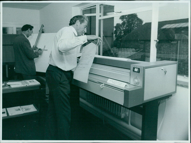 A model printer stand and drawer with paper exposure flash. - Vintage Photograph