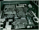 Mr. J. Troman, a planning draughtsman, moves a model machine in a model of 'K' Block Extension. - Vintage Photograph
