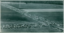 A helicopter flying over a military base on Laley Okley Air field. - Vintage Photograph