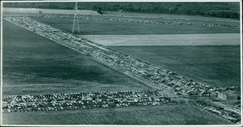 A helicopter flying over a military base on Laley Okley Air field. - Vintage Photograph