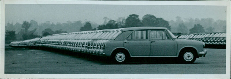 Cars driving on a road in Chipping Warden, England. - Vintage Photograph