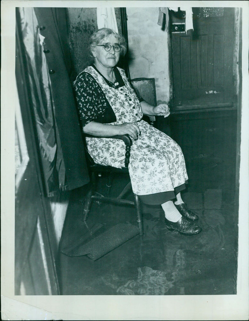 TE Ihre L Jones sits in a flooded room of her home in Wellington Street. - Vintage Photograph