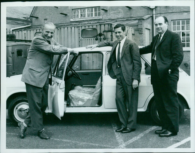 Sir Alec Issigonis, the creator of the Mini car, stands waist-deep in a river. - Vintage Photograph