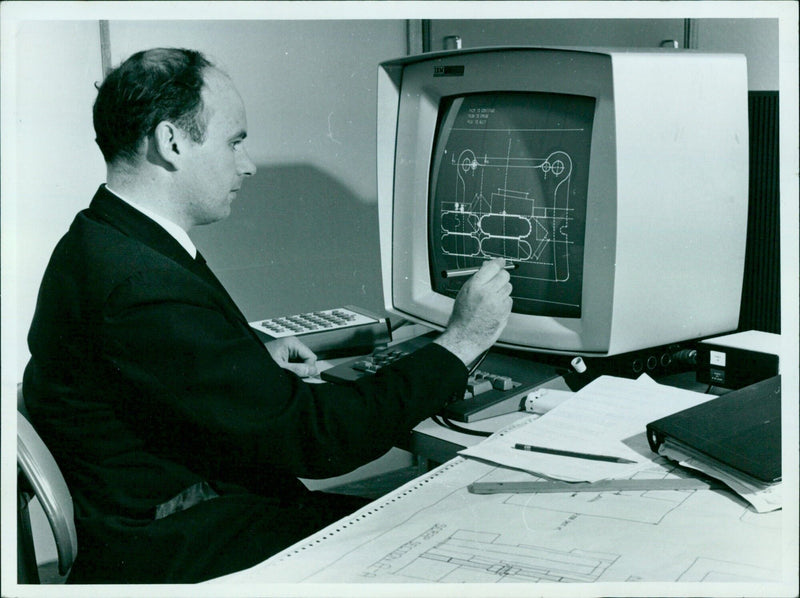A man uses a computer to design a 3D model of a turbine. - Vintage Photograph
