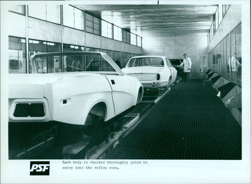 An employee inspects electronic components at a manufacturing facility. - Vintage Photograph