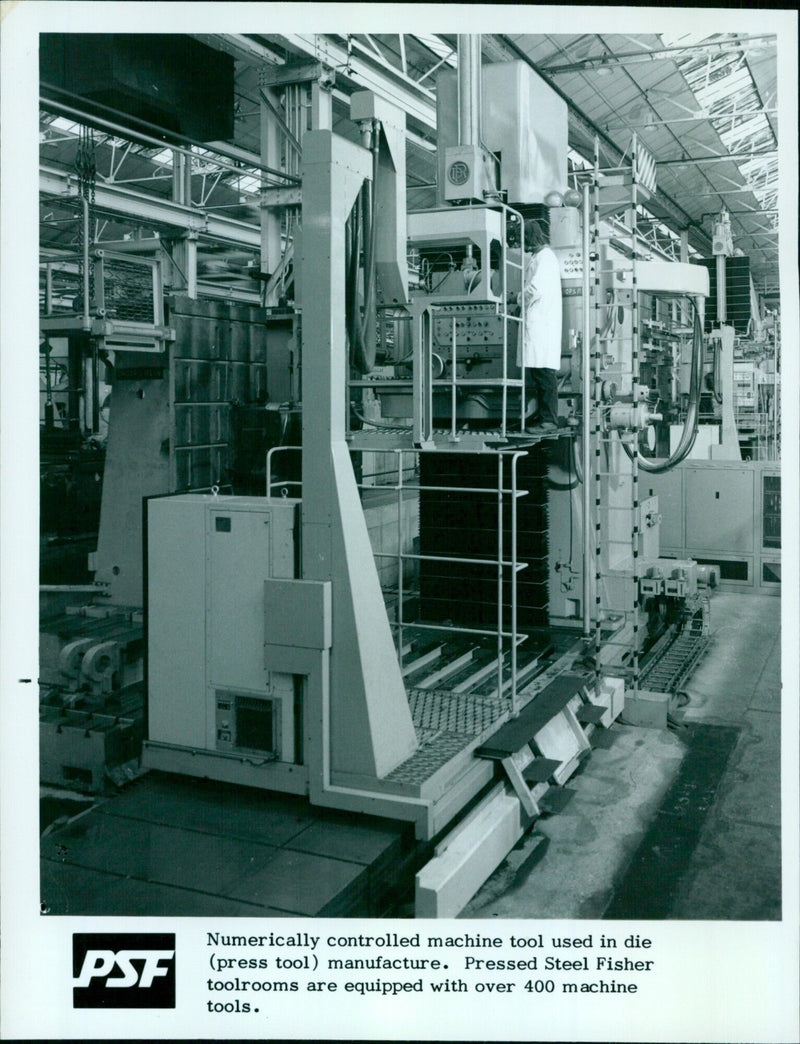 An employee inspects a numerically-controlled machine tool at a Pressed Steel Fisher toolroom. - Vintage Photograph