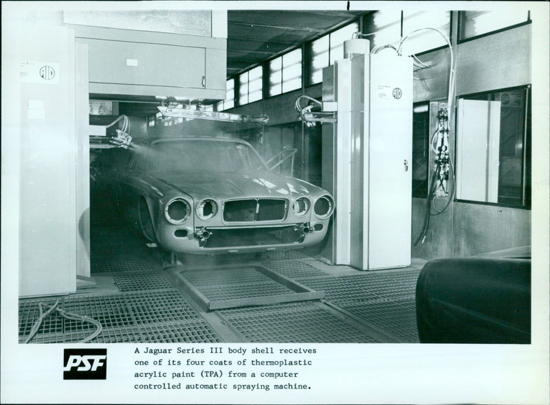 A Jaguar Series III body shell receives a coat of thermoplastic acrylic paint. - Vintage Photograph