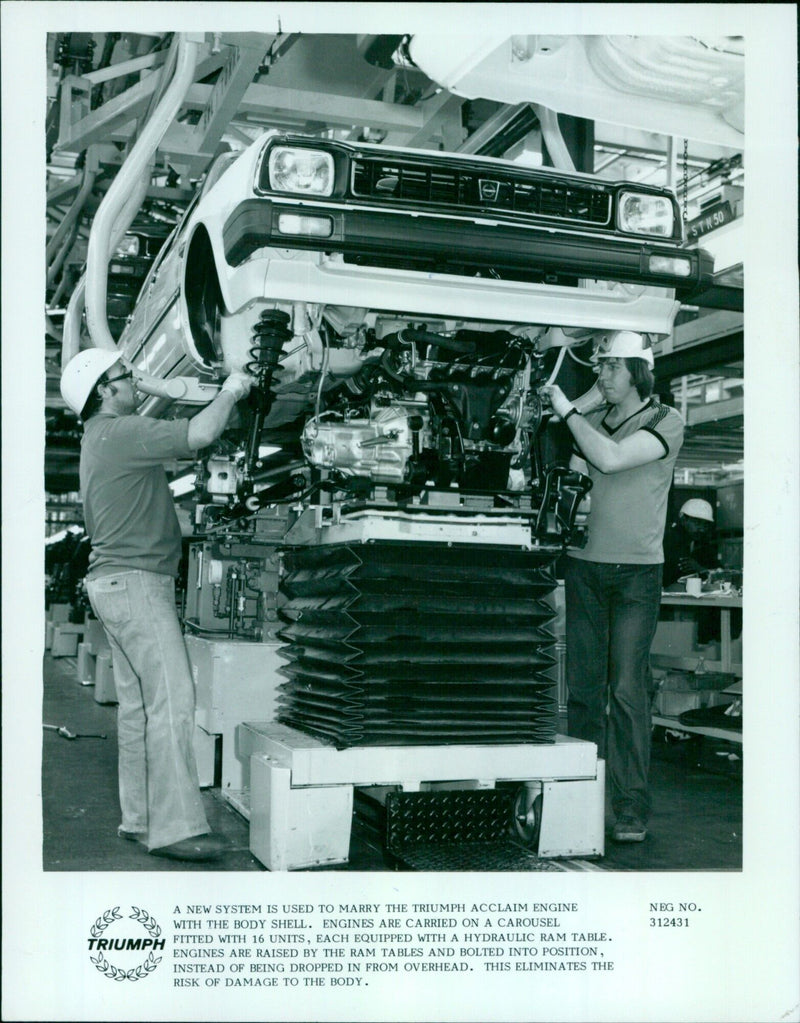 Workers at the Triumph Acclaim assembly plant use a carousel to install engines into the body shell. - Vintage Photograph