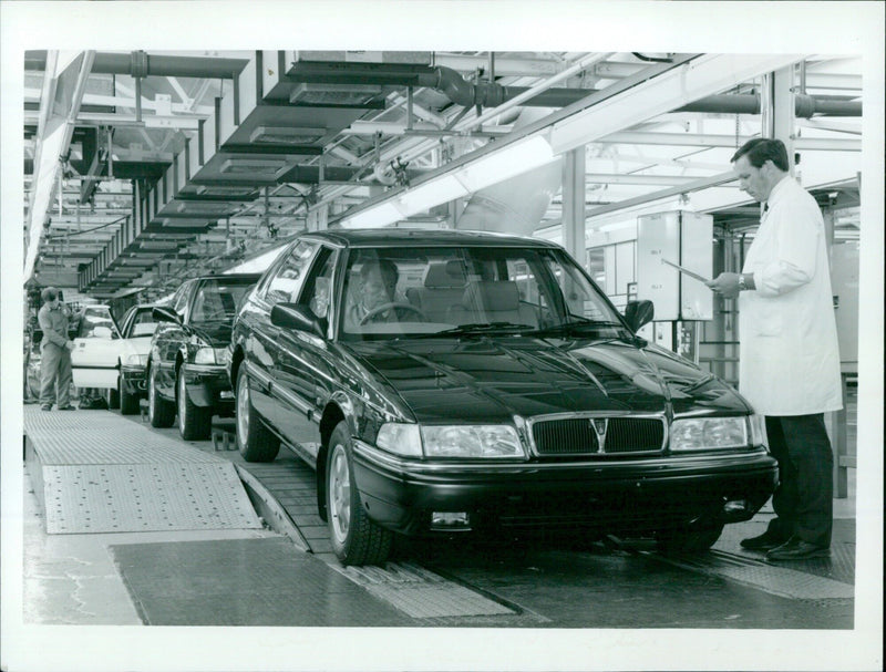 The manager of the Rover Planning Cliff Law cell inspects a Rover 800 car on the assembly line. - Vintage Photograph