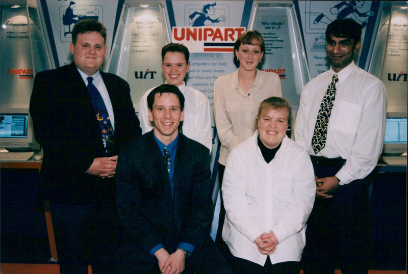 Five New Deal employees pose for a photo at Unipart. - Vintage Photograph