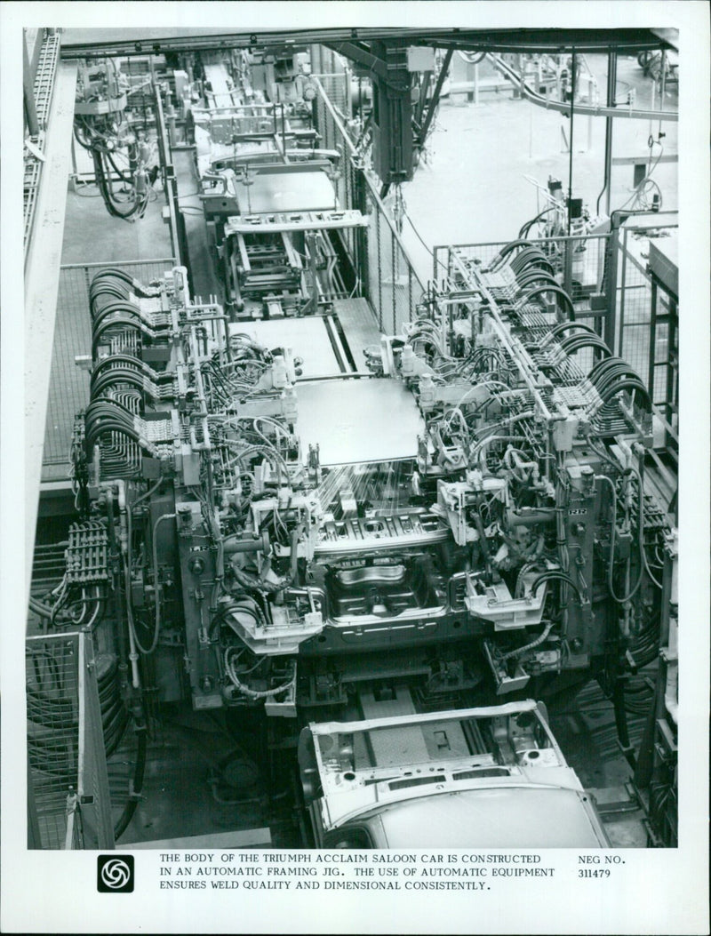 An automatic framing jig is used to construct the body of a Triumph Acclaim saloon car. - Vintage Photograph