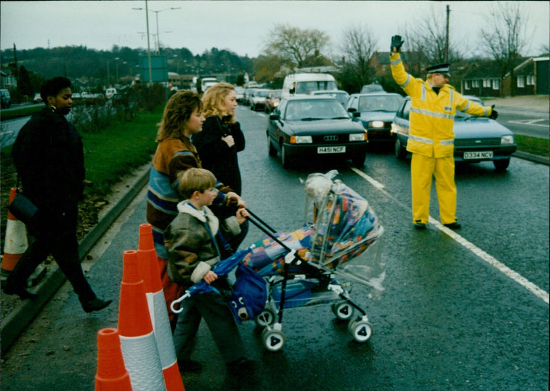 Contractors work on a roundabout as locals cross the busy road. - Vintage Photograph