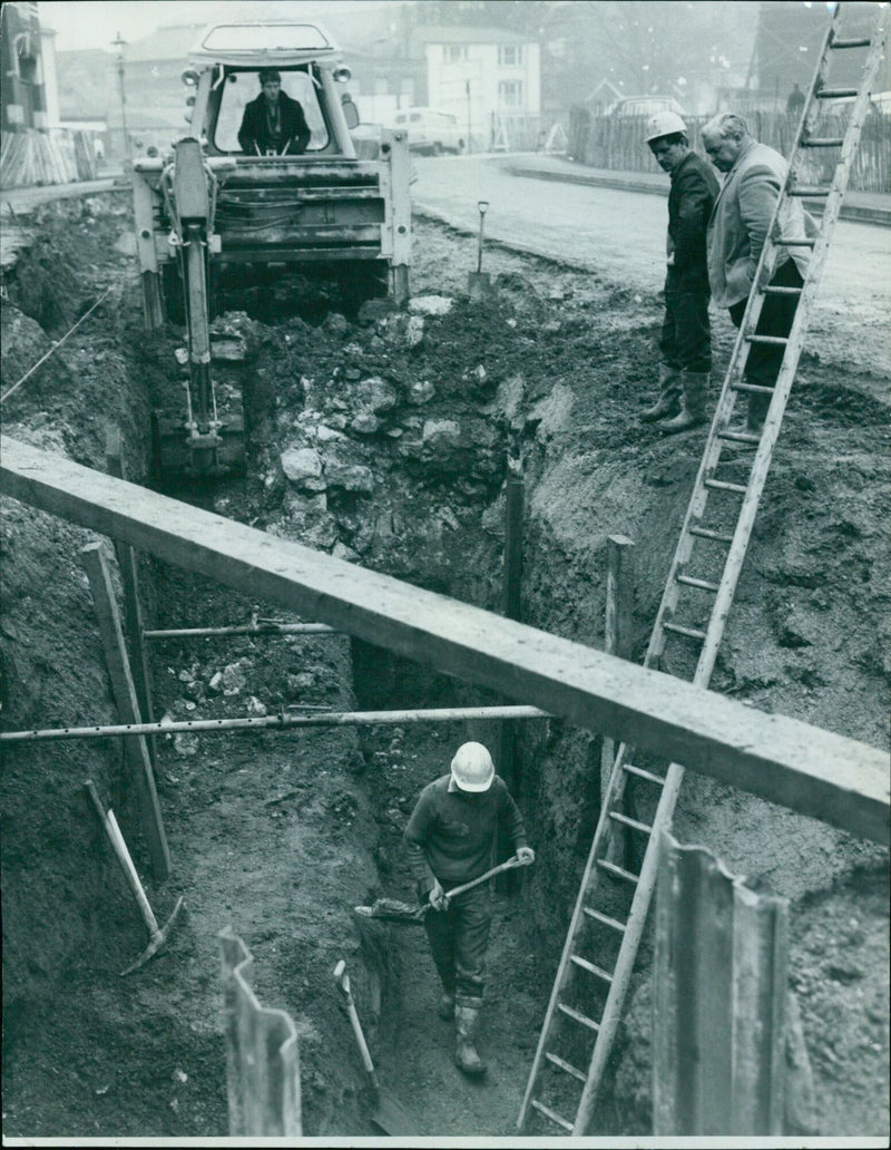 Men working in a deep hole as part of the Westgate development in Oxford, England. - Vintage Photograph