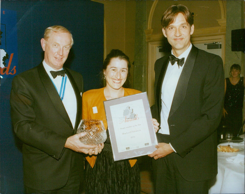 John Bridgeman presents the People Investor of the Year award to Frances Matker and Rene Olivieri of Blackwell Publishers. - Vintage Photograph