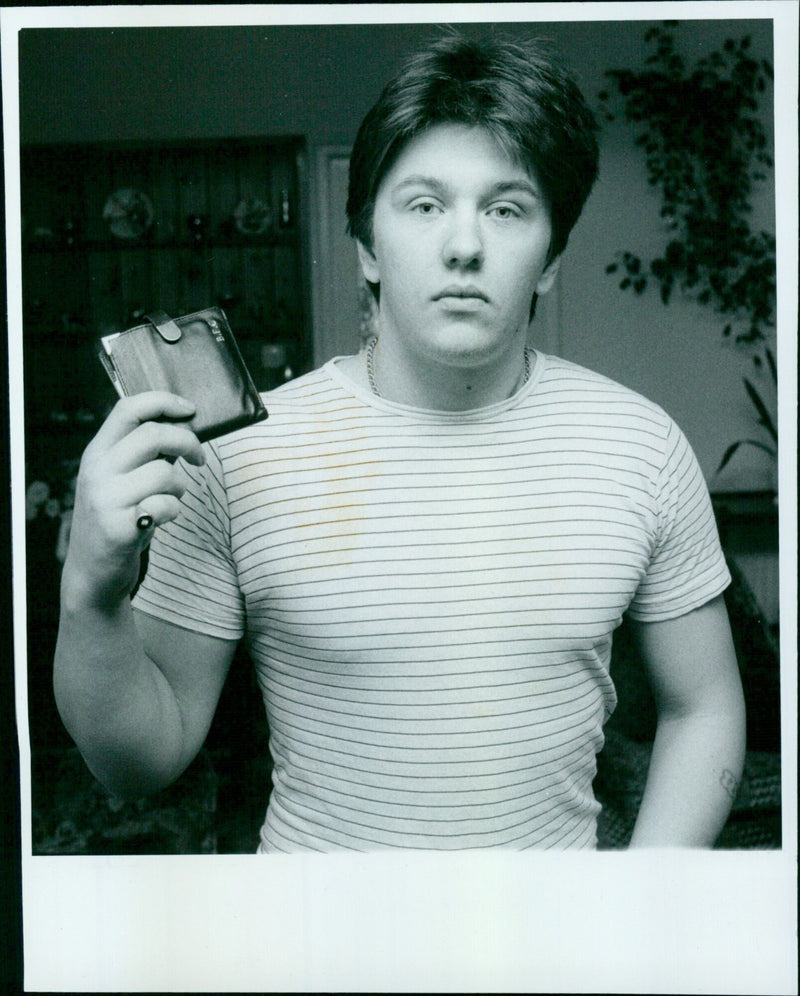 A man holds his wallet as two police officers look on. - Vintage Photograph